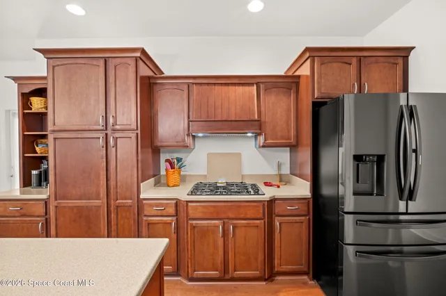 a kitchen with stainless steel appliances granite countertop a refrigerator and a stove