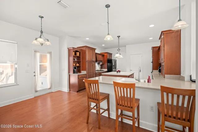 a view of a dining room and livingroom with furniture wooden floor a chandelier