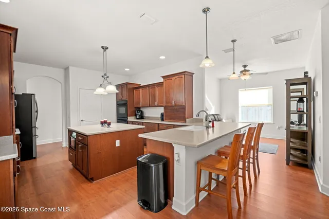 a large kitchen with kitchen island a island a stove a sink a center island and a wooden floor