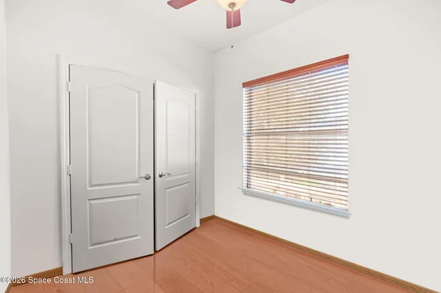 a view of an empty room with a window and closet area