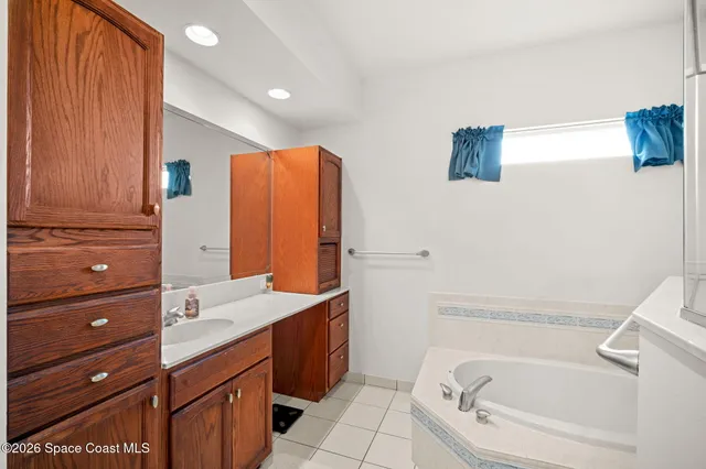 a bathroom with a tub sink and mirror