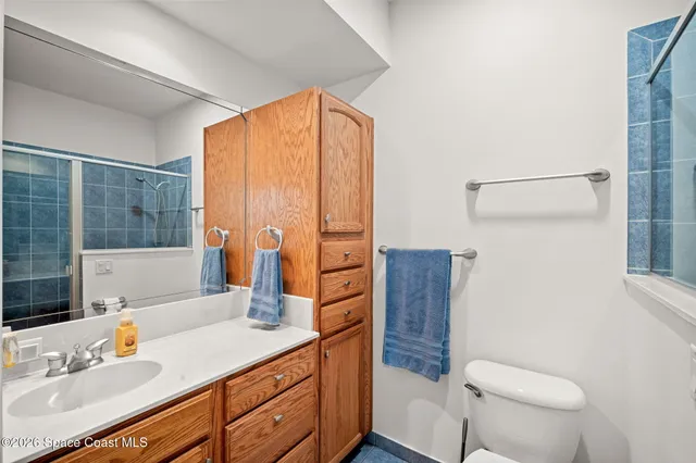 a bathroom with a granite countertop sink a toilet and shower