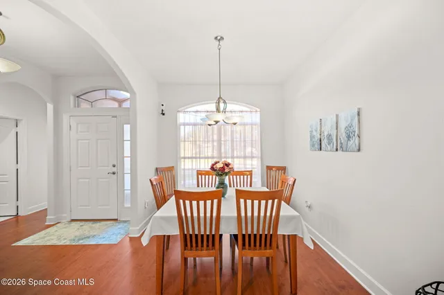 a view of a hallway with windows and chandelier