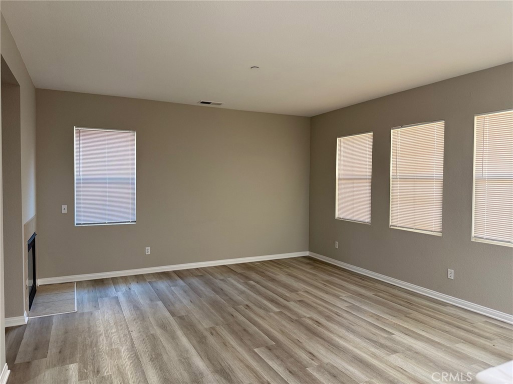 4547 Nicole Way Riverside, CA 92501 - Photo 17 of 36 an empty room with wooden floor and windows
