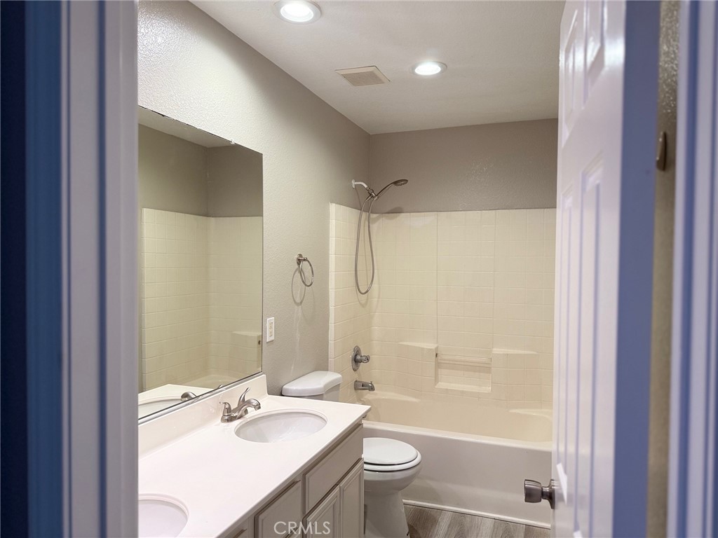 4547 Nicole Way Riverside, CA 92501 - Photo 33 of 36 a bathroom with a bathtub shower sink vanity and toilet