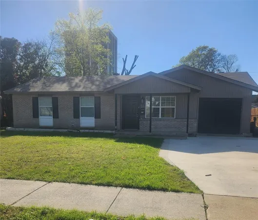 a front view of a house with a garden and yard