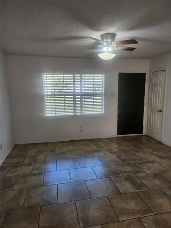 a view of a livingroom with a chandelier fan and windows