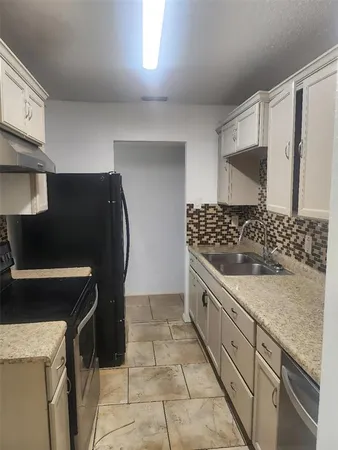 a kitchen with granite countertop a stove and a sink