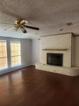 an empty room with windows and fireplace