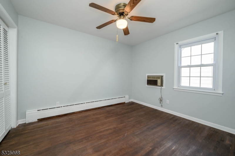 136 Valpeck Avenue, Unit 1 Raritan, NJ 08869 - Photo 26 of 37 an empty room with wooden floor fan and windows