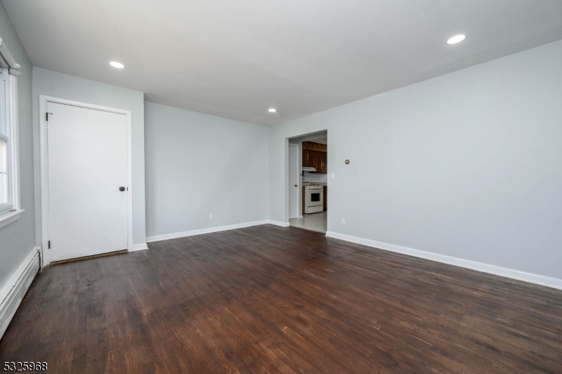136 Valpeck Avenue, Unit 1 Raritan, NJ 08869 - Photo 5 of 37 a view of an empty room with wooden floor and a window