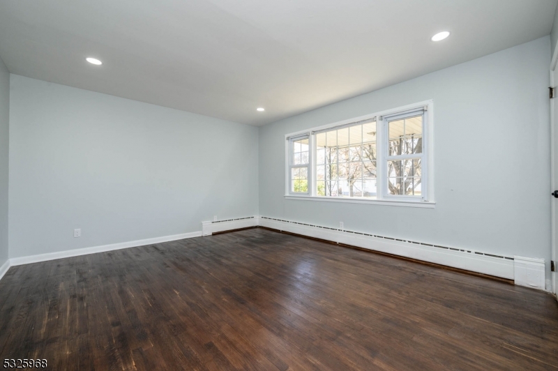 136 Valpeck Avenue, Unit 1 Raritan, NJ 08869 - Photo 7 of 37 an empty room with wooden floor and windows