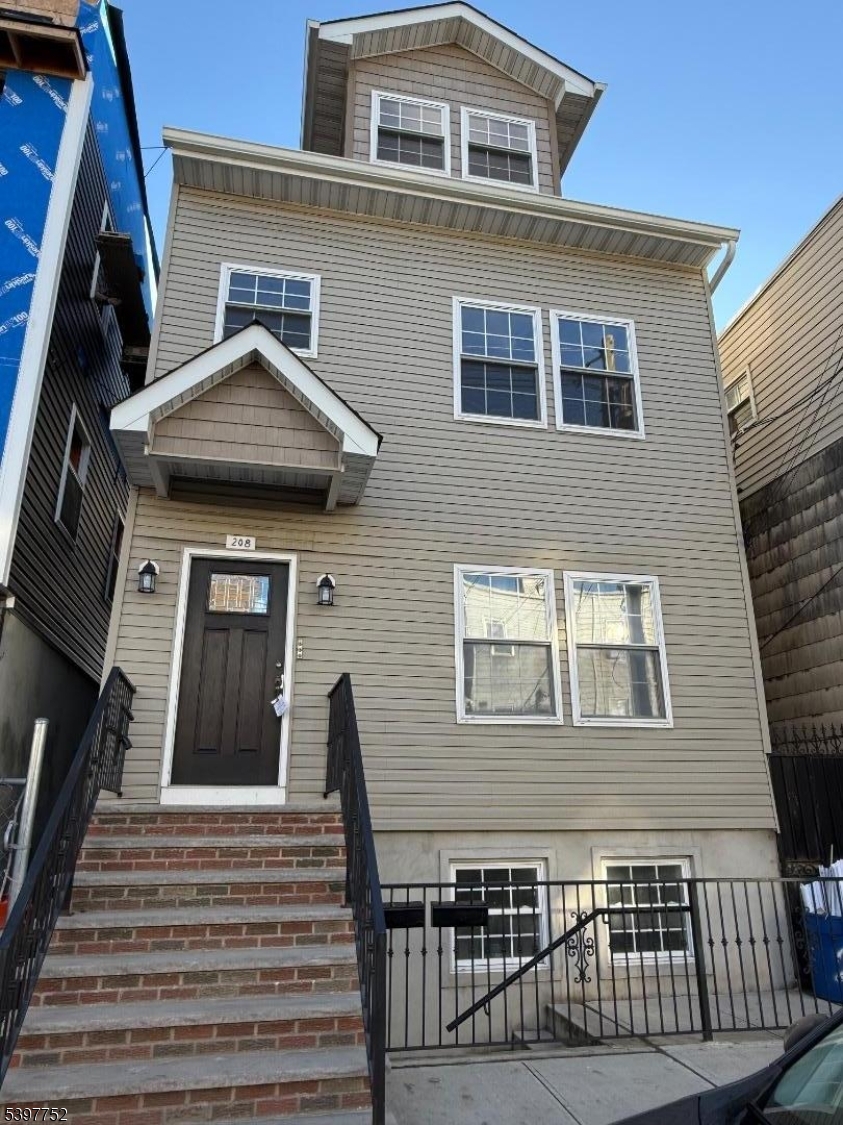 208 Walnut Street Newark, NJ 07105 - Photo 1 of 18 a front view of a house with a yard