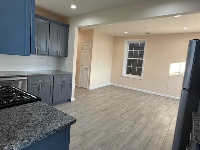 a view of a kitchen with wooden floor and windows
