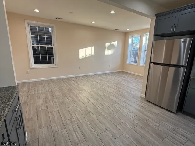 a view of a kitchen with wooden floor and refrigerator