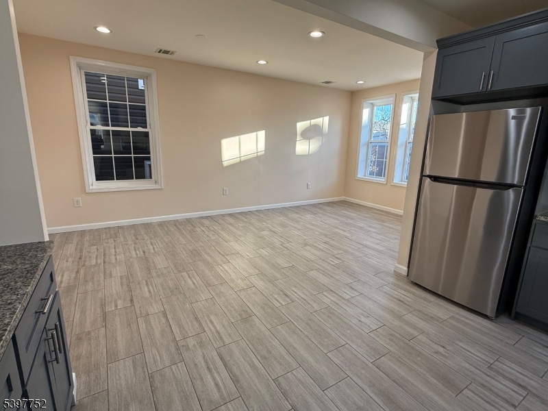 208 Walnut Street Newark, NJ 07105 - Photo 6 of 18 a view of a kitchen with wooden floor and refrigerator