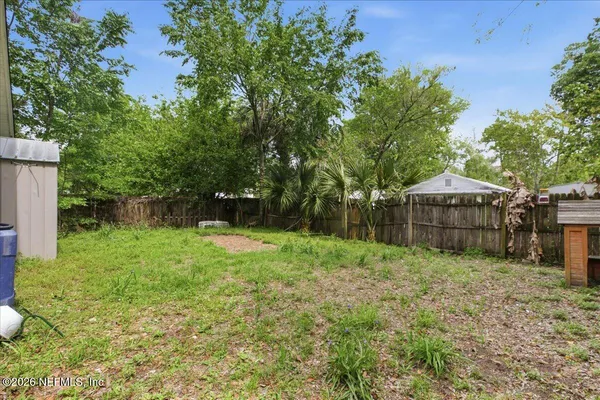 a backyard of a house with plants and tree