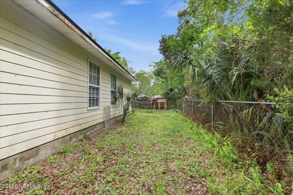 a backyard of a house with table and chairs