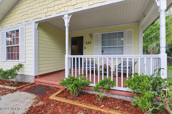 a view of a house with a small yard and flower plants