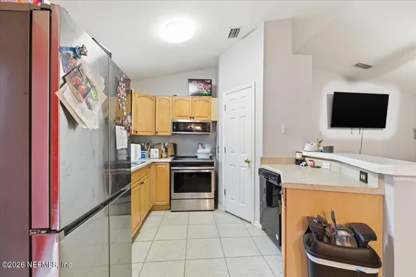 a kitchen with stainless steel appliances kitchen island granite countertop a refrigerator oven a sink and dishwasher