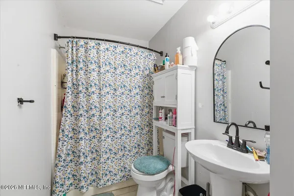 a bathroom with a sink toilet and a mirror