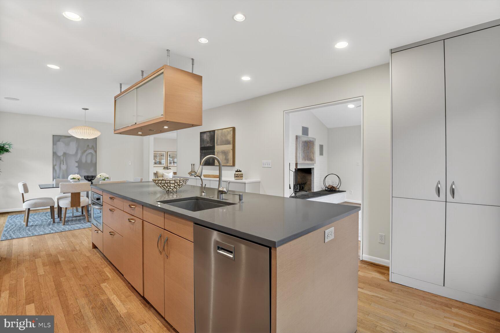 6104 Robinwood Road Bethesda, MD 20817 - Photo 12 of 45 a kitchen with kitchen island a sink and a stove top oven with wooden floor