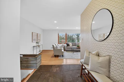 a living room with furniture a rug and a mirror