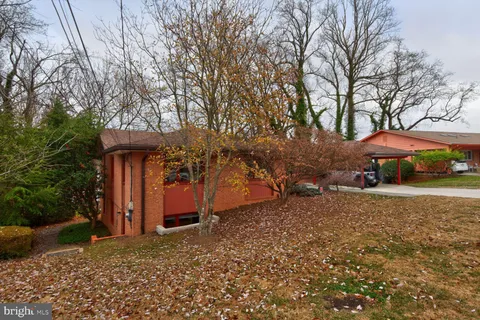 a view of a house with backyard and trees