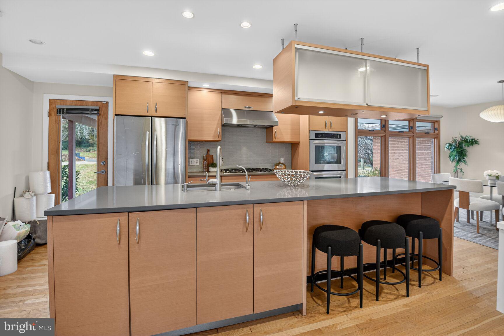6104 Robinwood Road Bethesda, MD 20817 - Photo 9 of 45 a kitchen with stainless steel appliances granite countertop a table chairs sink and cabinets