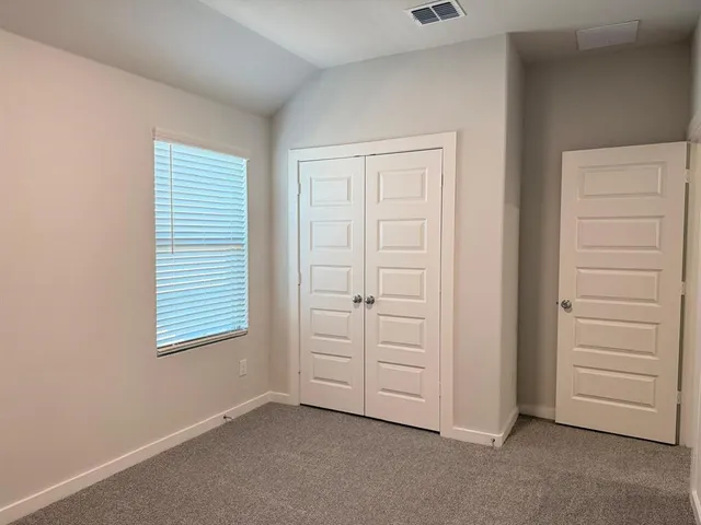an empty room with windows and closet