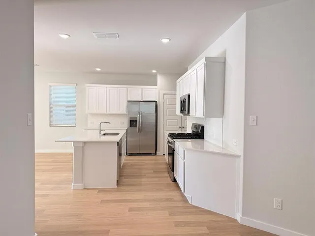 a kitchen with granite countertop white cabinets and black appliances