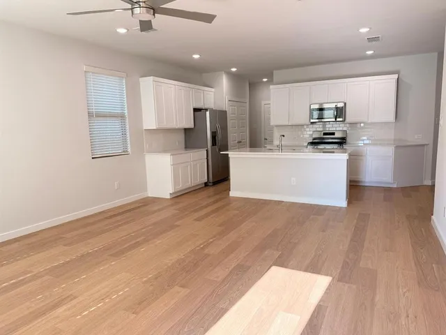 a kitchen with a refrigerator and white cabinets