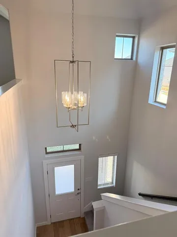 a view of a hallway with windows and chandelier