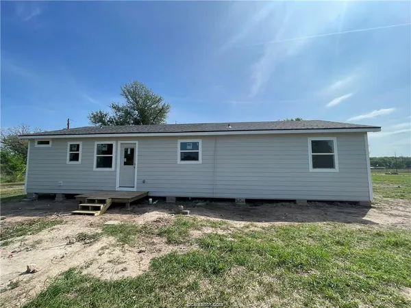 a view of a house with a backyard