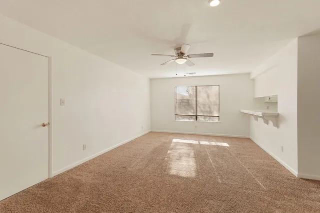 a view of an empty room with a fireplace and a window