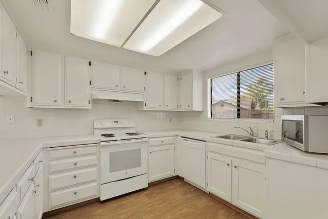 a kitchen with stainless steel appliances granite countertop a sink and cabinets