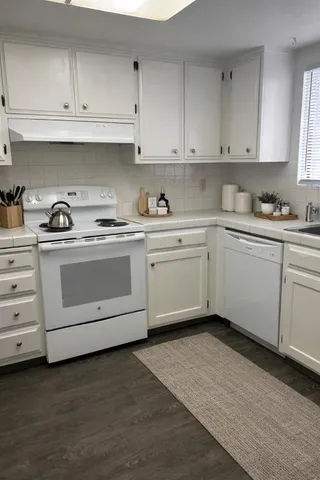 a kitchen with white cabinets and a sink