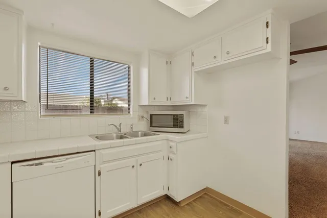 a kitchen with white cabinets and white appliances