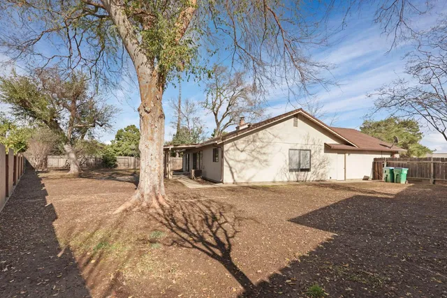 a view of a house with a backyard and trees