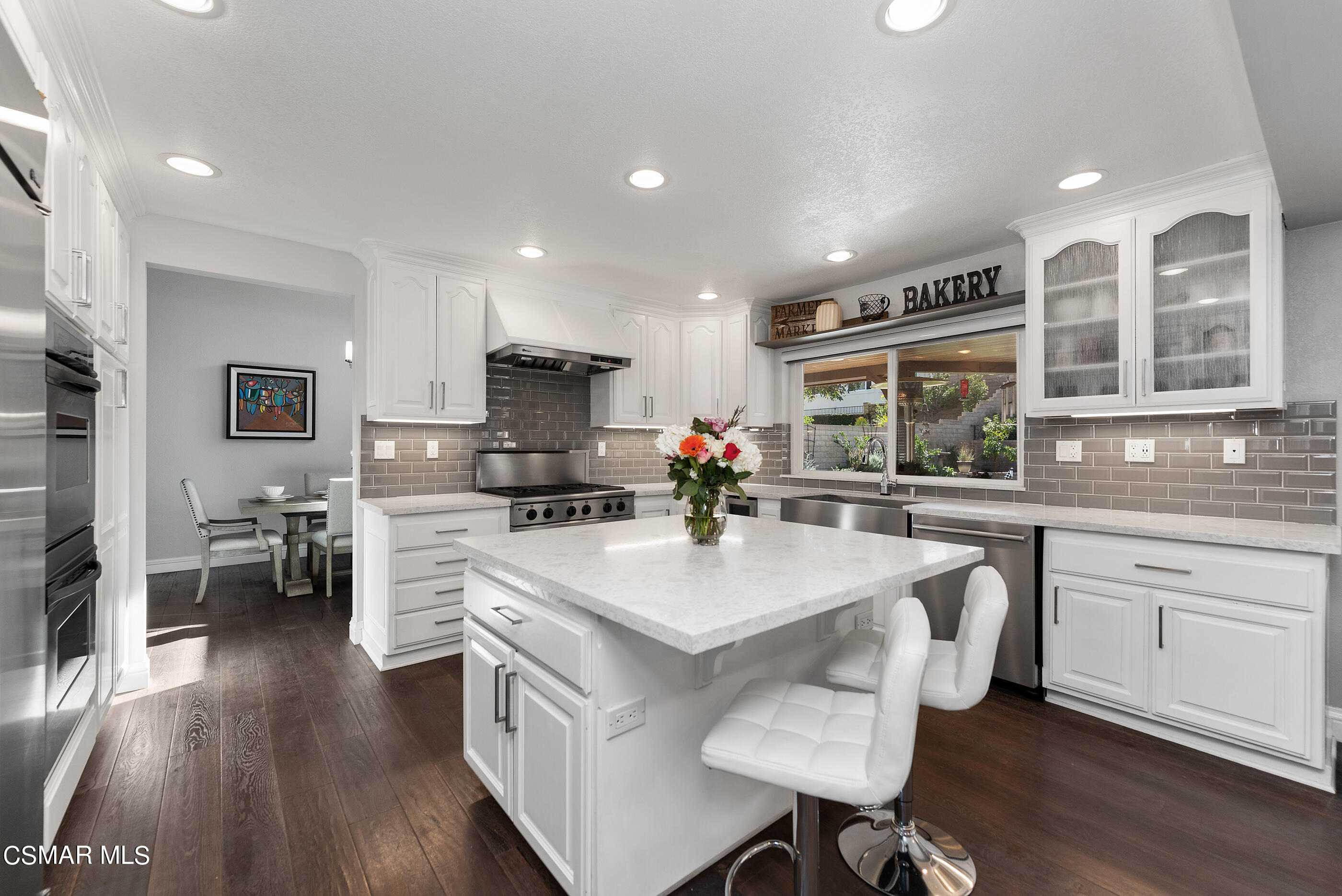 3233 Crazy Horse Drive Simi Valley, CA 93063 - Photo 22 of 65 a kitchen with stainless steel appliances granite countertop a stove a sink dishwasher a stove and white cabinets with wooden floor