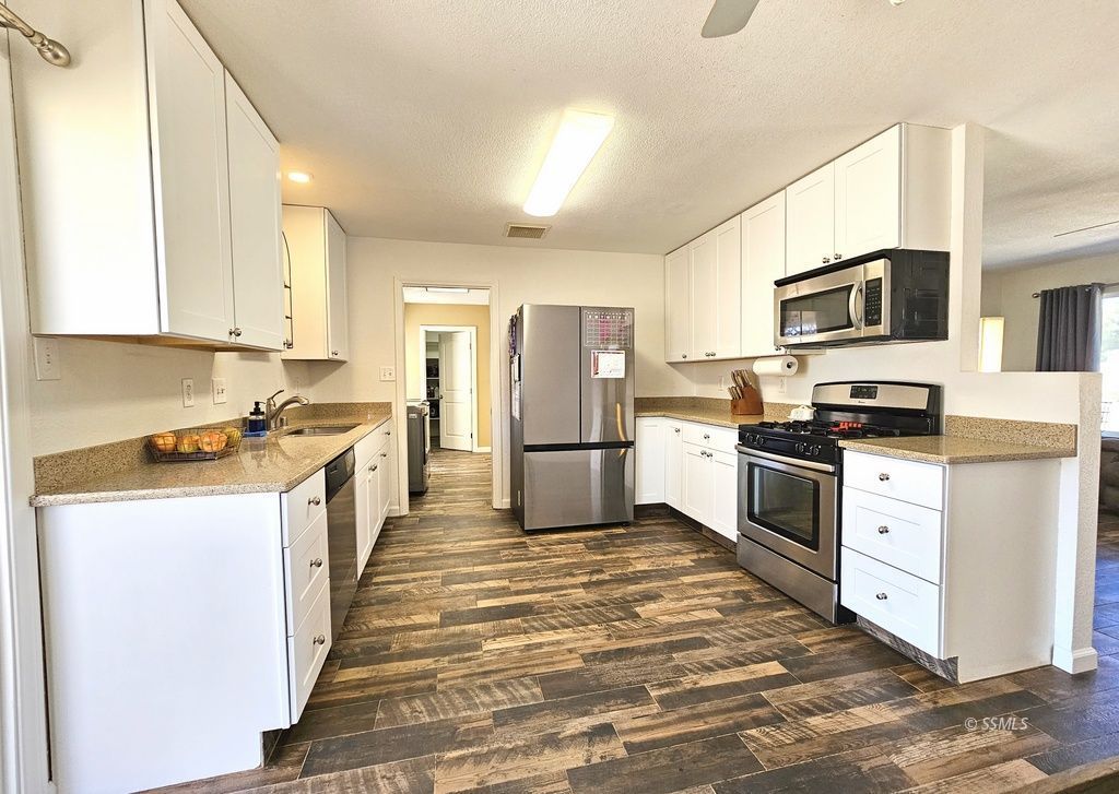 630 South Sunset Street Ridgecrest, CA 93555 - Photo 5 of 34 a kitchen with granite countertop a refrigerator and a stove top oven