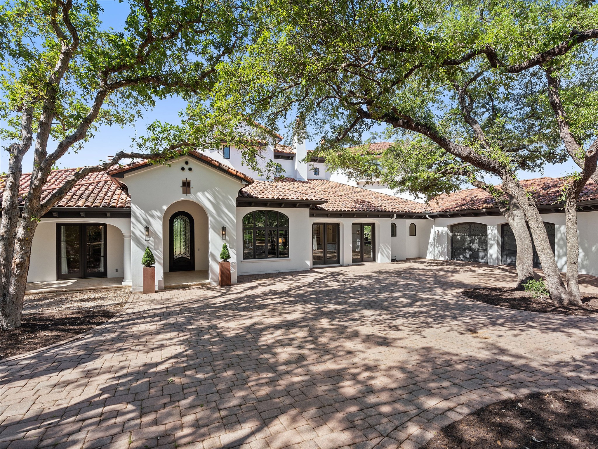 The property features a charming exterior with a tiled roof and a paved driveway