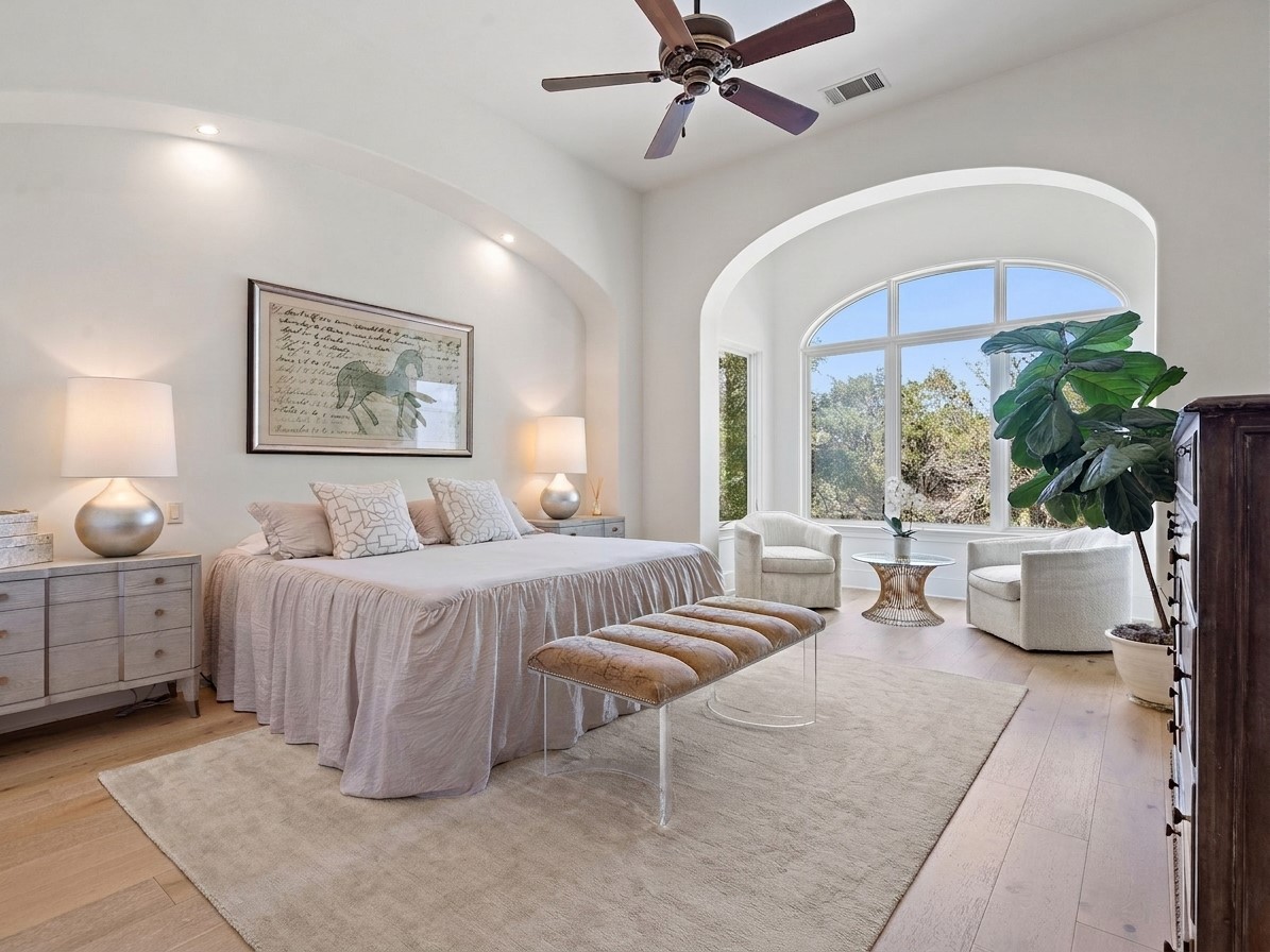 11620 Musket Rim Street Austin, TX 78738 - Photo 12 of 32 a spacious bedroom with a bed and a chandelier
