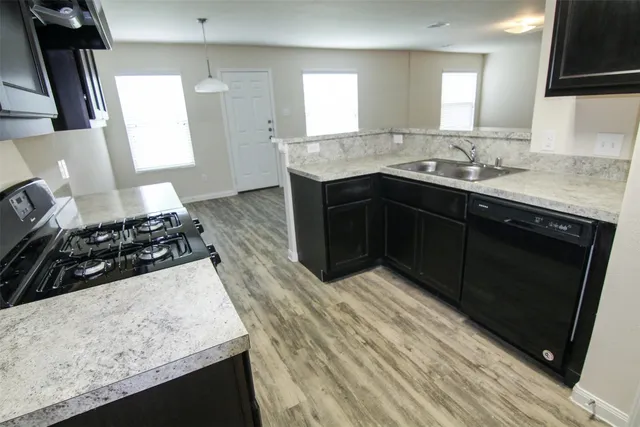 a kitchen with stainless steel appliances granite countertop wooden cabinets stove and sink