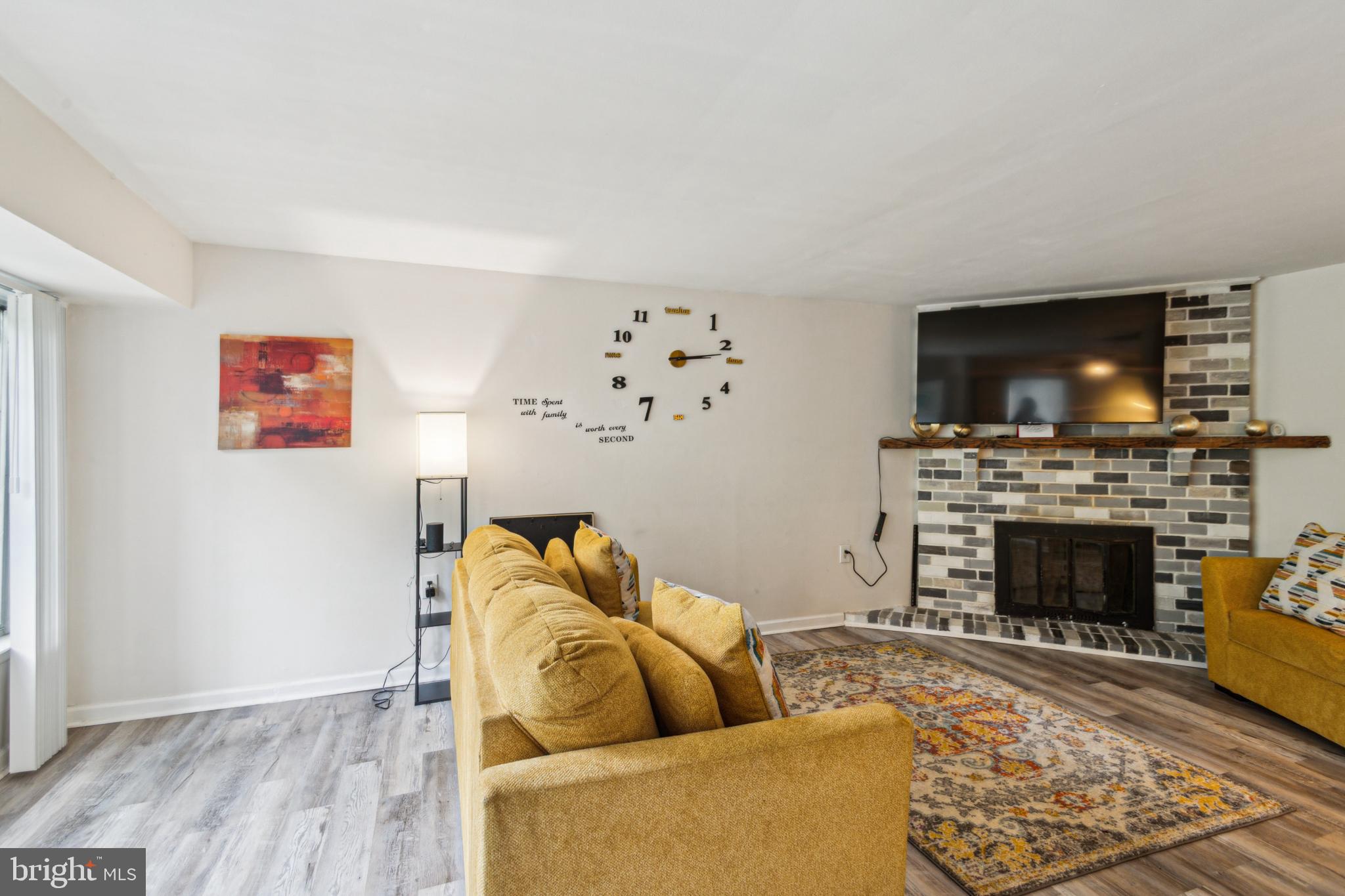 1008 Timber Creek Road Clementon, NJ 08021 - Photo 15 of 24 a living room with furniture a flat screen tv and a fireplace