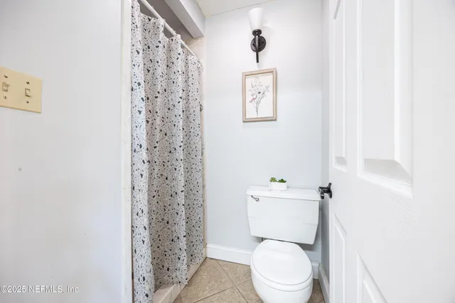 a white toilet sitting next to a shower curtain