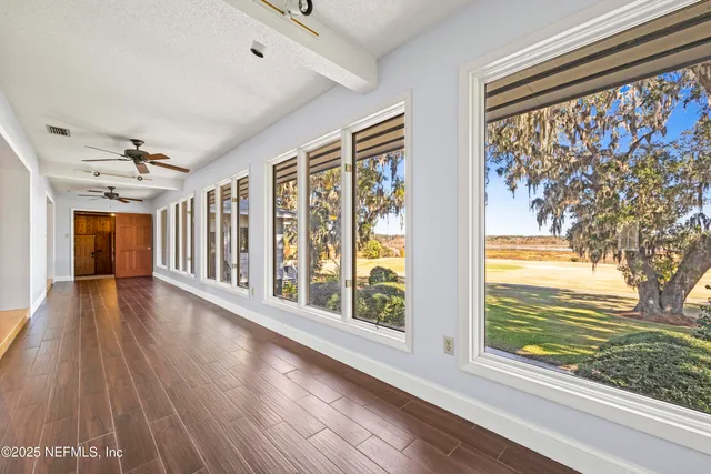 a view of a room with wooden floor and windows