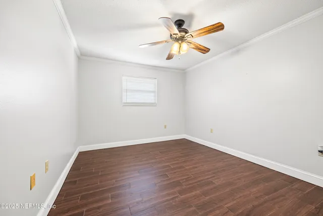 a view of an empty room with wooden floor