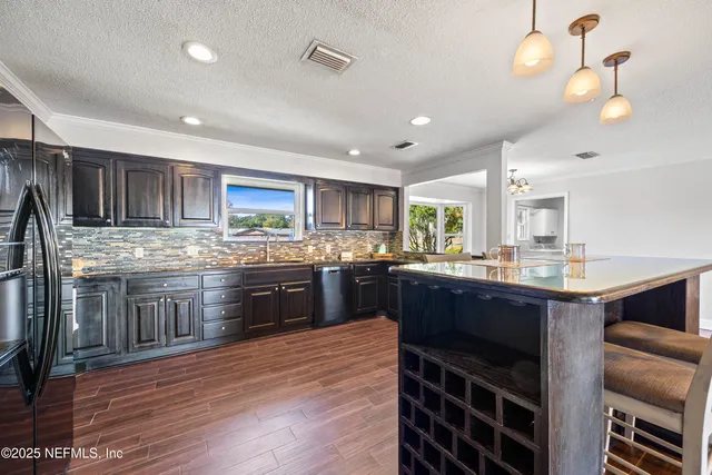 a kitchen with stainless steel appliances granite countertop wooden cabinets a stove top oven a sink and dishwasher