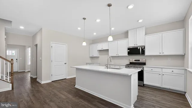 a kitchen with kitchen island a sink stainless steel appliances and cabinets